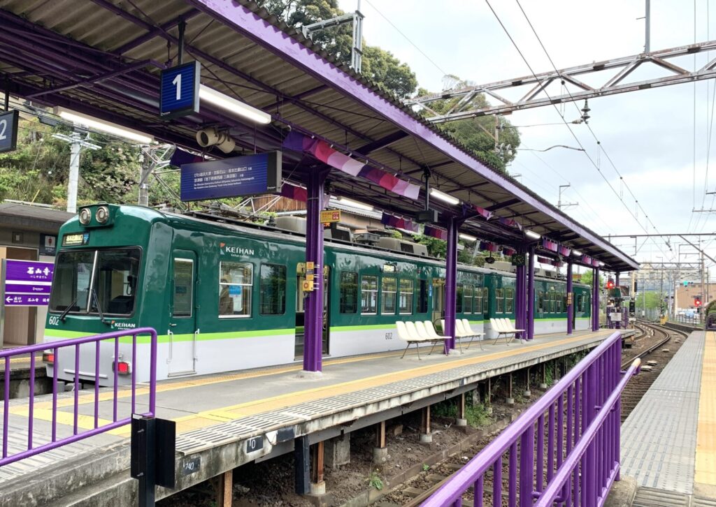 紫色の駅舎に宇治色の電車が美しいです。